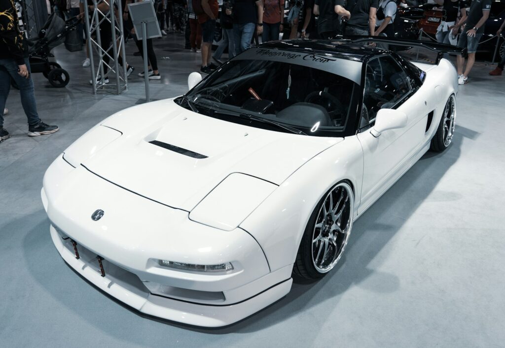 a white sports car on display at a car show
