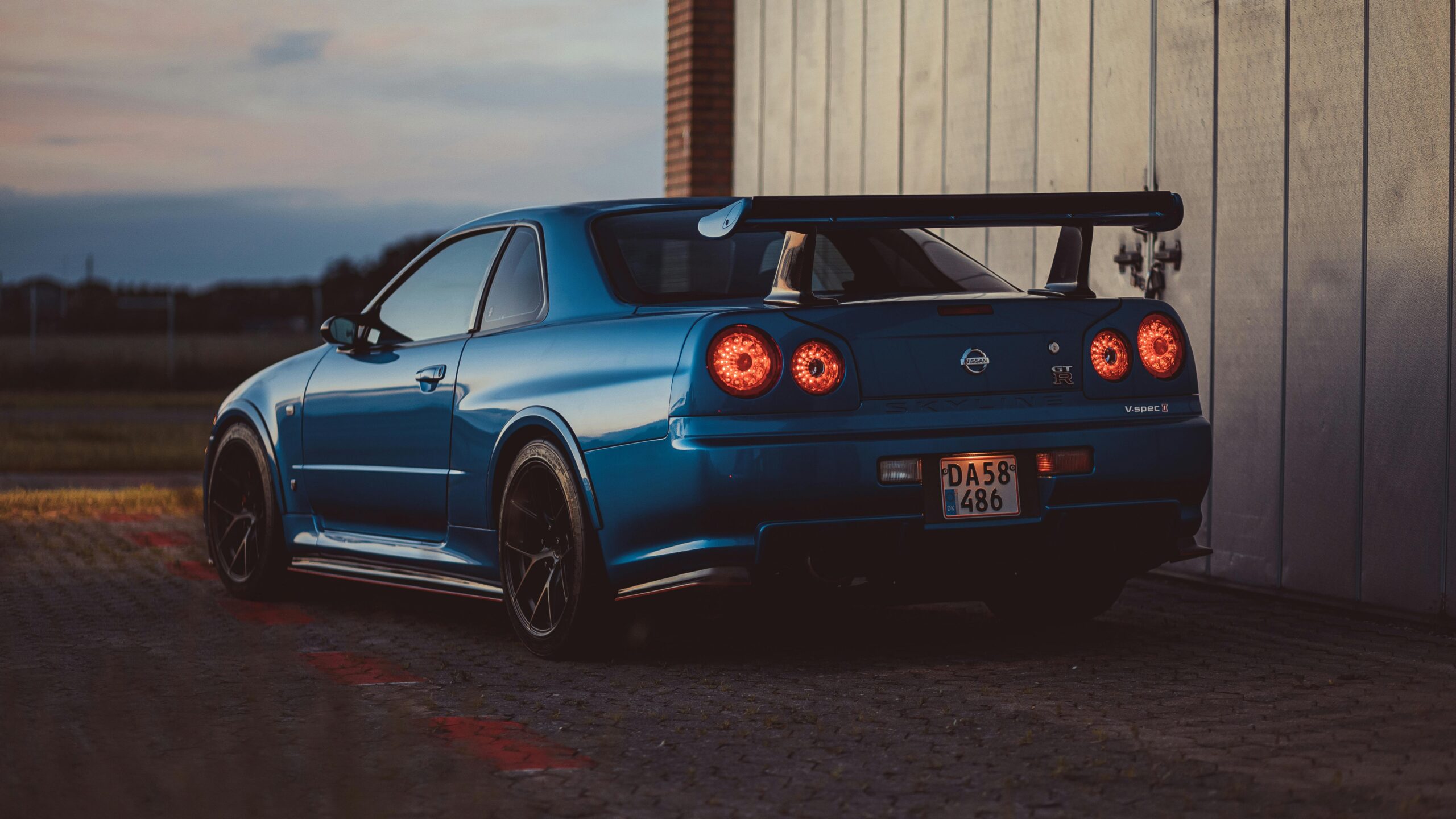 A blue Nissan Skyline GTR parked outdoors at twilight in Roskilde, Denmark.