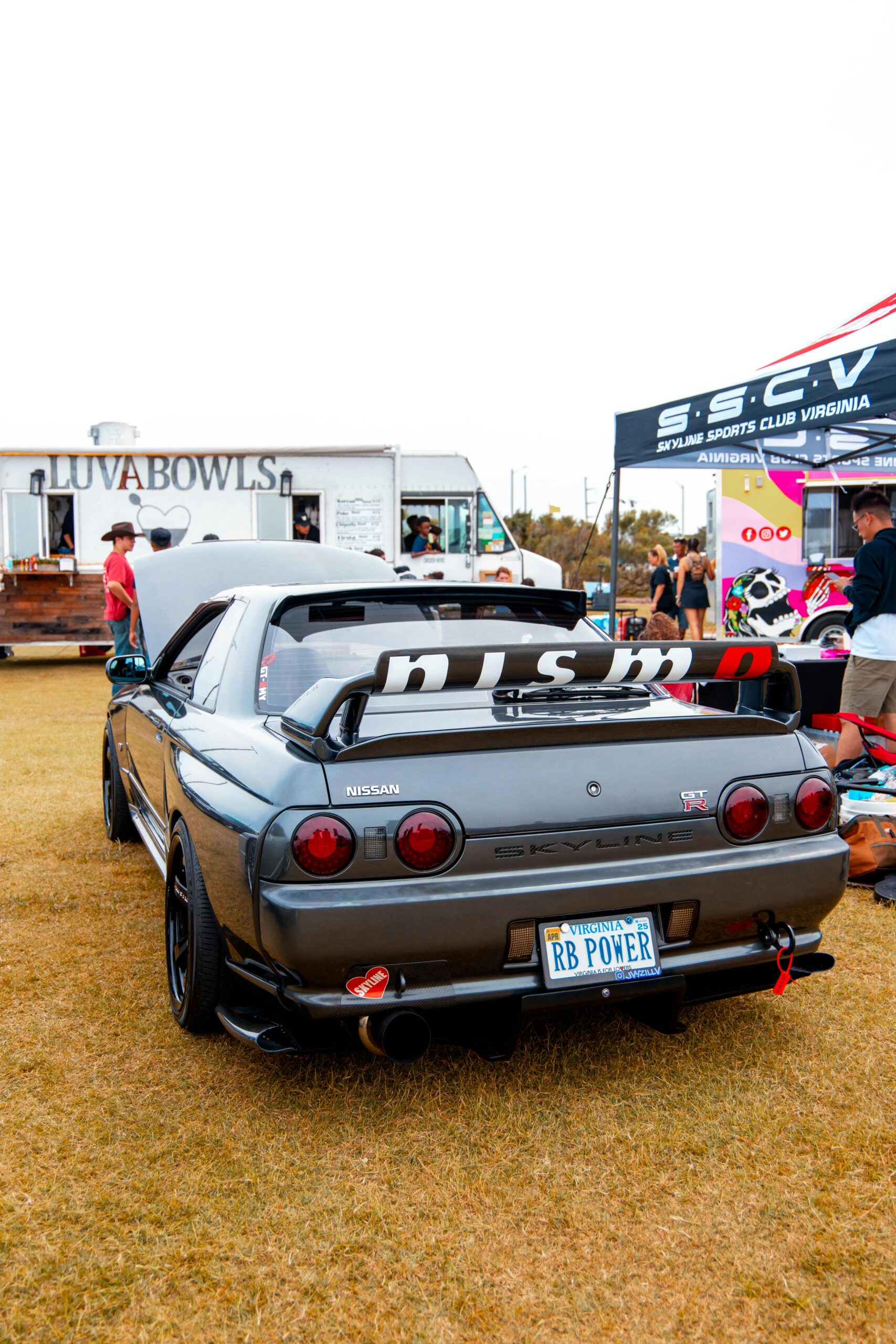 Rear view of a Nissan Skyline GT-R at an outdoor car event.