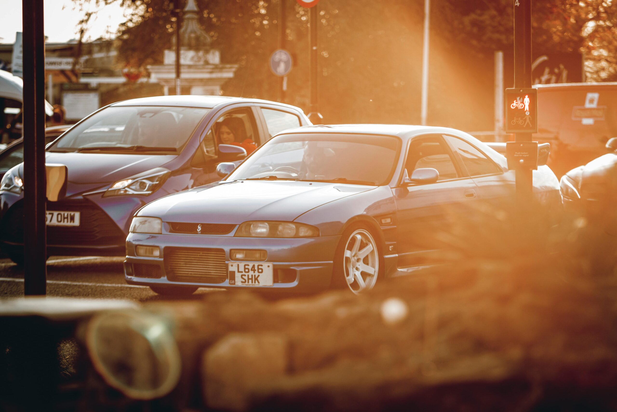 Capture of urban cars at sunset, showcasing a Nissan Skyline in a city setting.