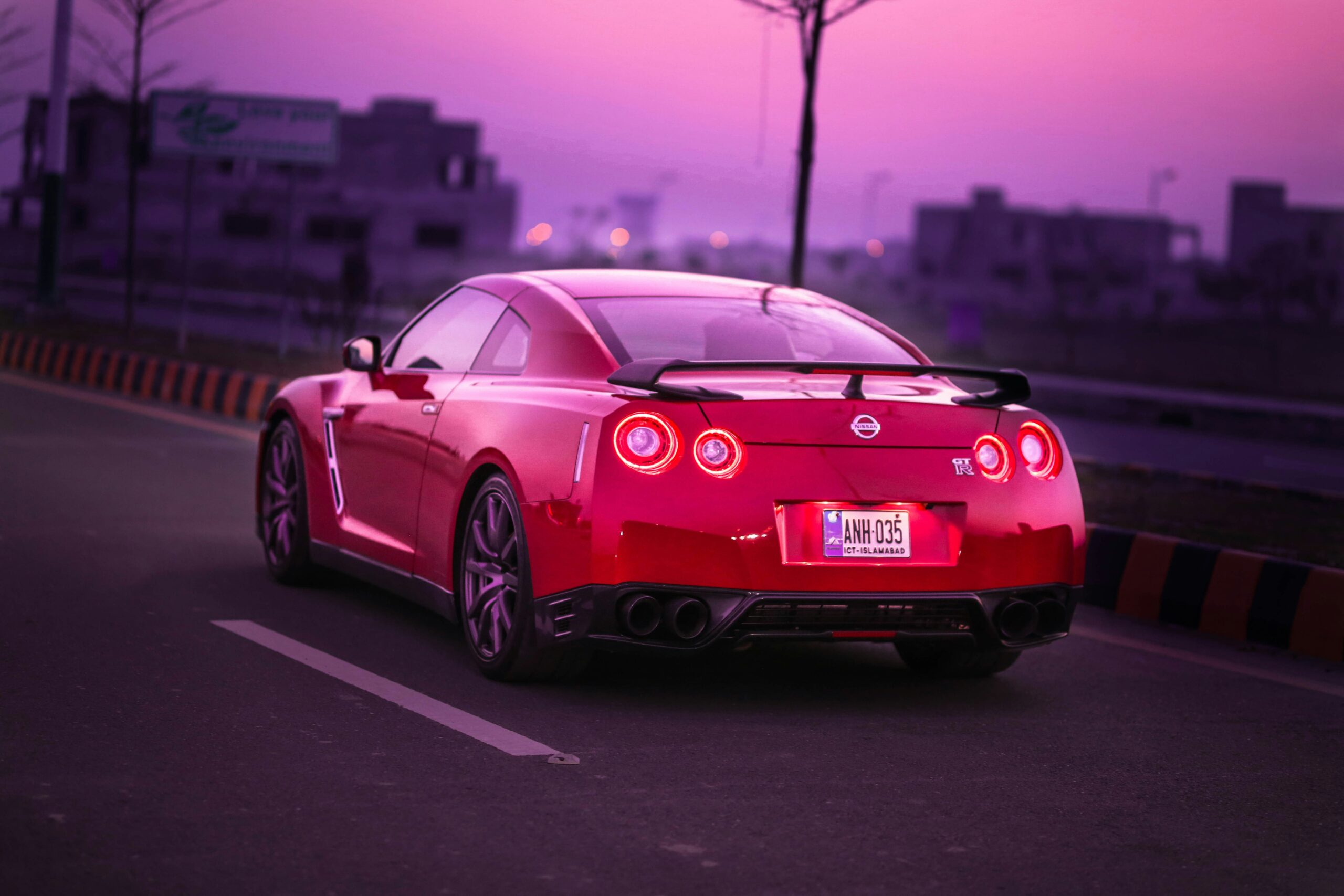 a red sports car driving down the road