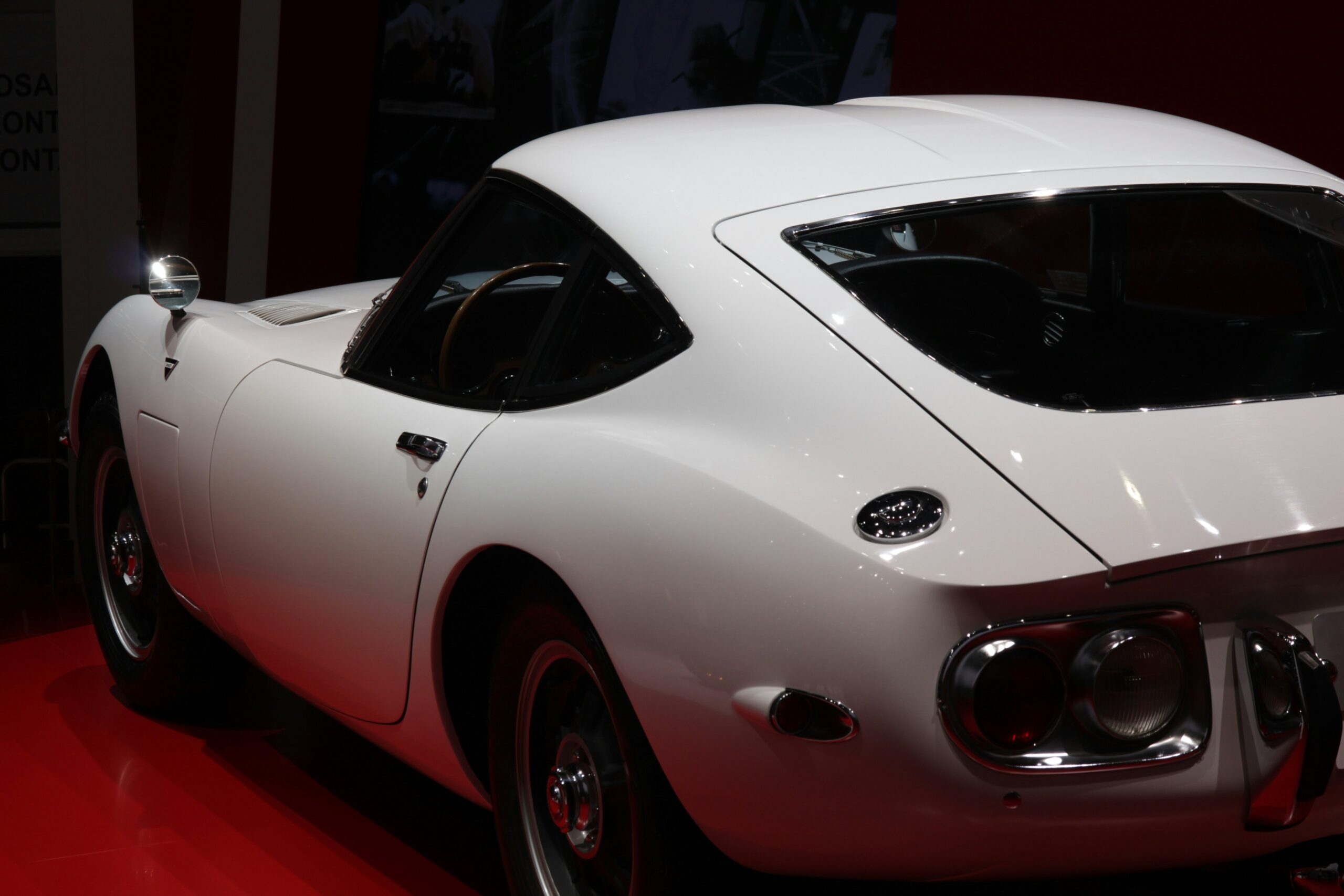 a white sports car on display at a car show  By Christian Paul Stobbe
