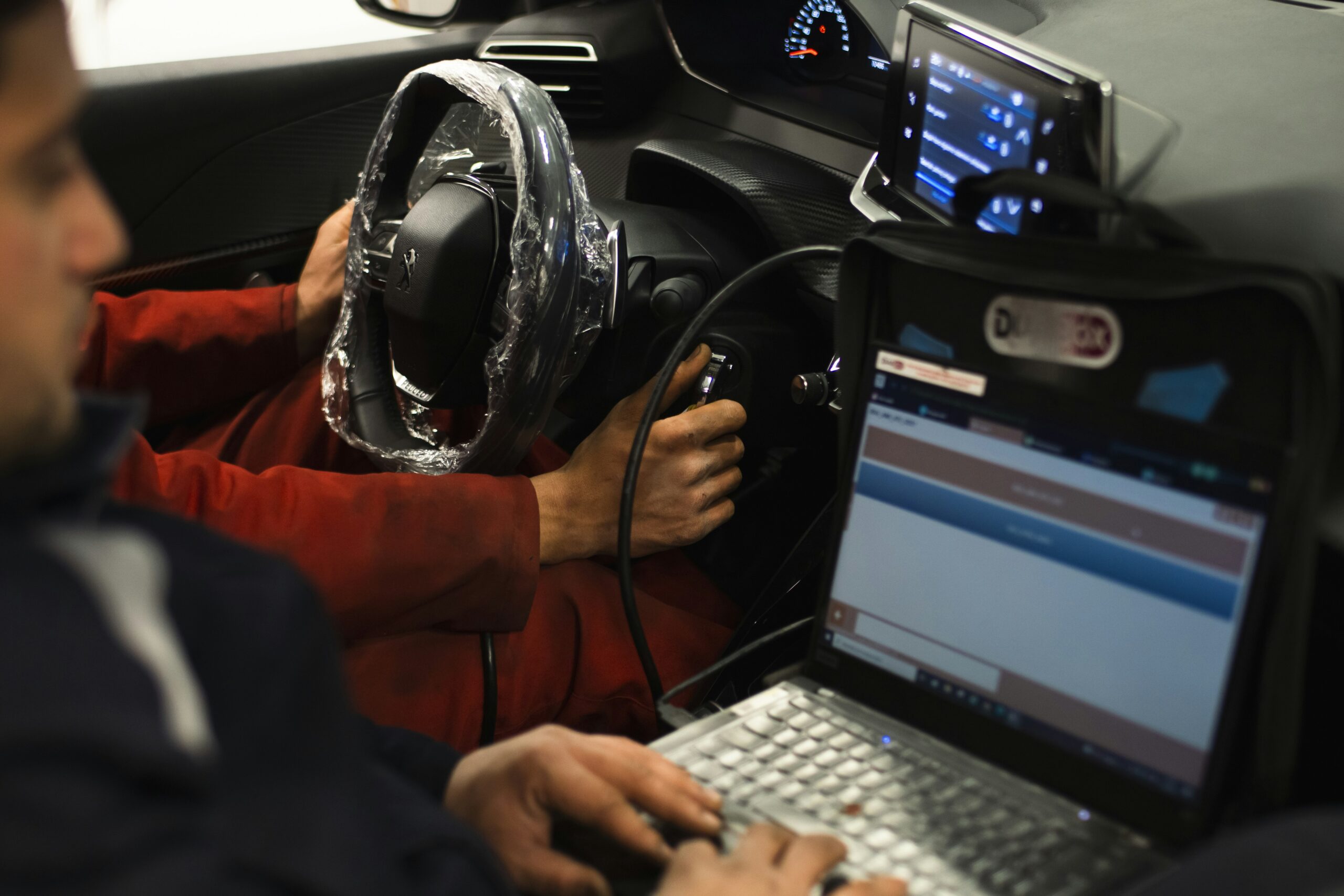 A man sitting in a car using a laptop computer  By Mehmet Talha Onuk